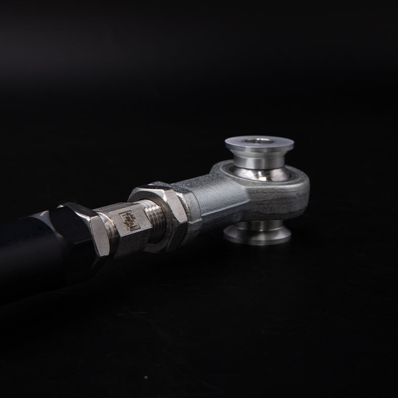 Suspension Secrets adjustable rear toe arms for BMW G87 M2, close-up of black suspension linkage with branded logo.