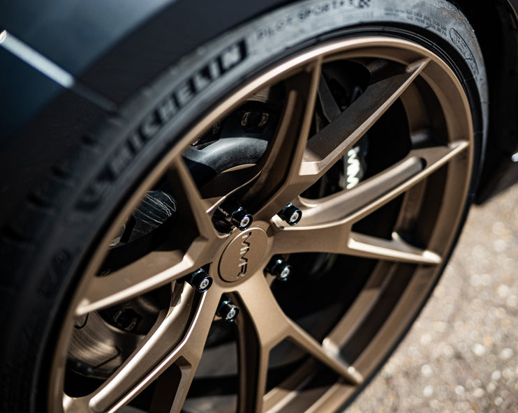 BMW Mini wheel stud and nut conversion kit by MMX Performance, featuring six stud and nut components for wheel installation.