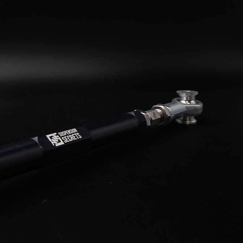 Suspension Secrets adjustable rear toe arms for BMW G87 M2, showing metal linkage with mounting points and hardware.