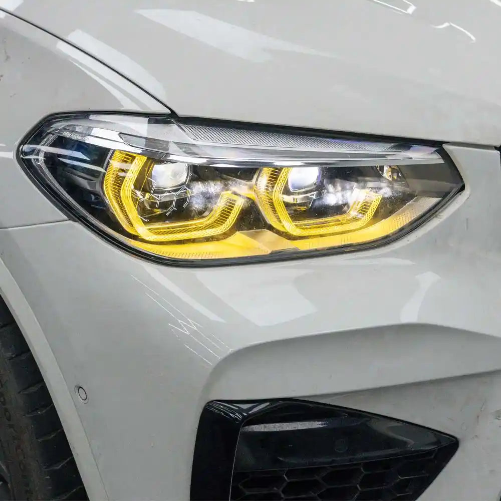 BMW F98 X4M pre-LCI yellow adaptive DRL module set by CT Carbon, featuring bright LED daytime running lights for 2018-2021 models.