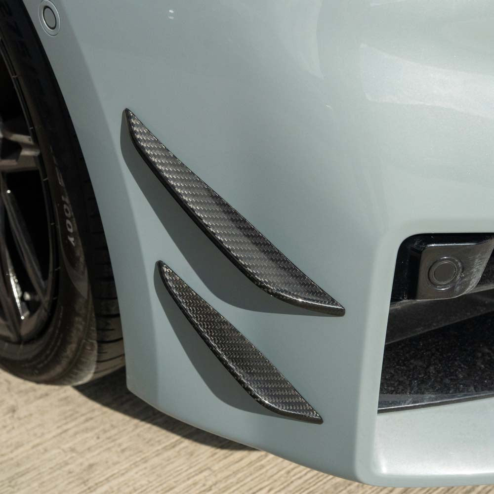 BMW G87 M2 carbon fibre front bumper canards by CT Carbon, showing sleek aerodynamic design and lightweight construction.