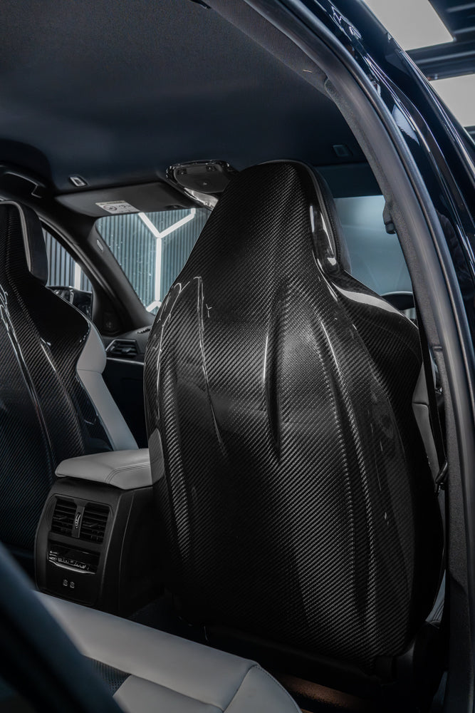 BMW GXX/F9X full carbon fibre seats backs by CT Carbon, showcasing sleek, lightweight carbon fiber material and detailed finish.