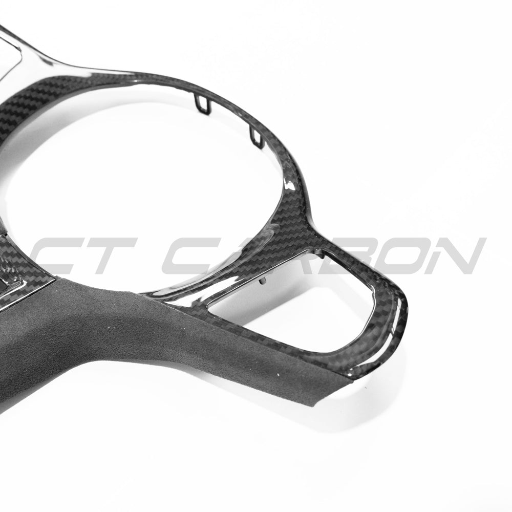 BMW Gxx M Sport carbon fibre steering wheel trim accessory by CT Carbon, showing the sleek, textured carbon fibre surface.