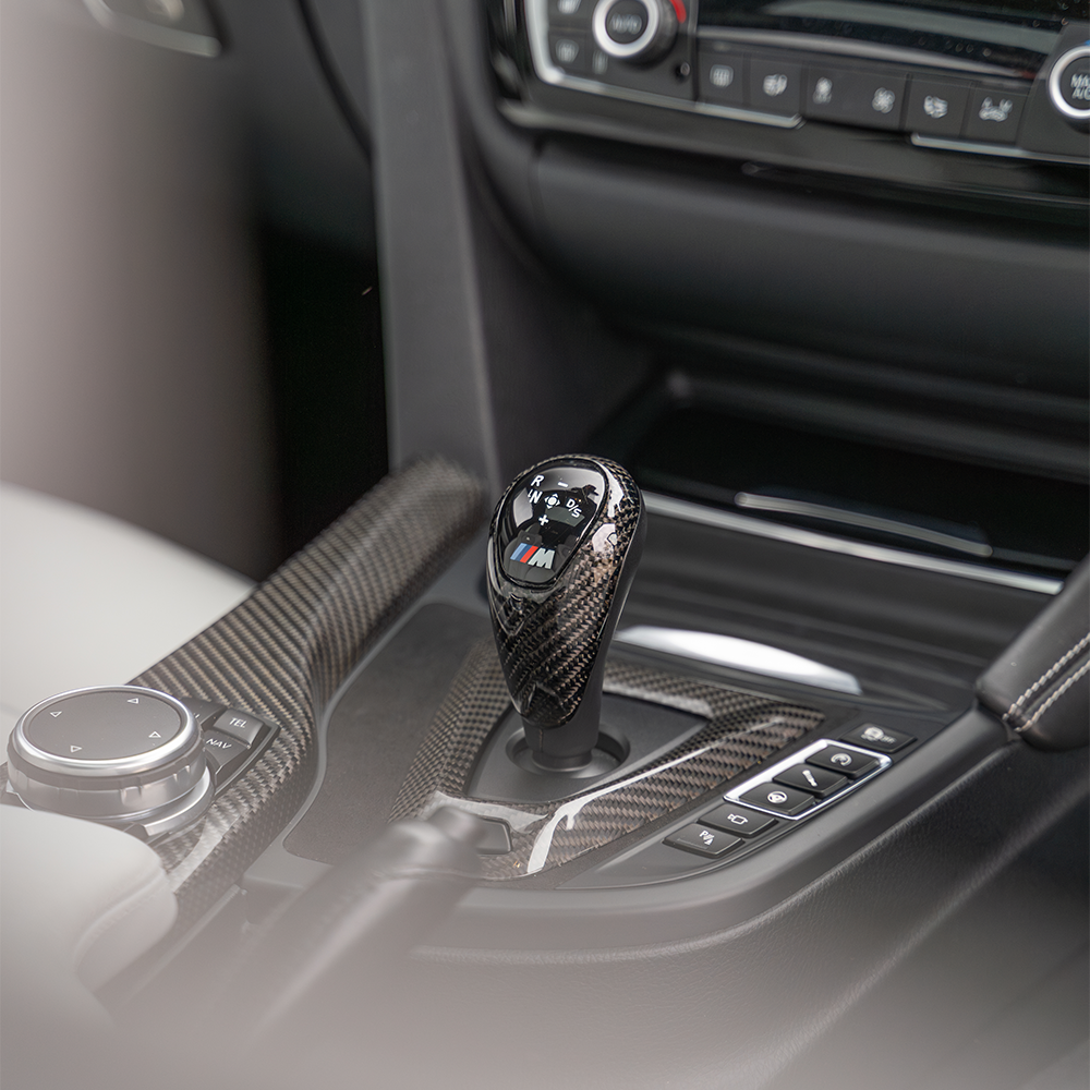 BMW M3 M4 F80 F82 F83 F87 ALCANTARA and carbon shifter surround accessory by CT Carbon, showing a sleek black interior trim piece.