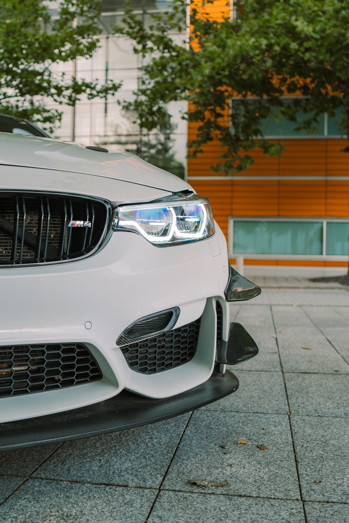 Carbon GT4 side canards for BMW M3 and M4 F80/F82, front bumper trim from Nineteen72 Performance, mounted on the vehicle.