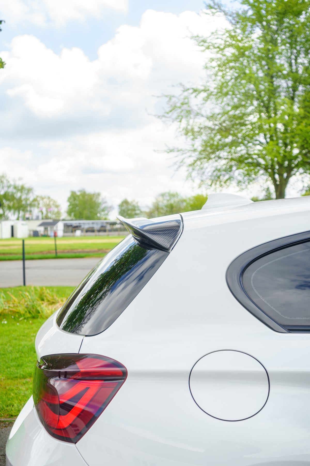 BMW 1 Series F20 gloss carbon fibre performance style spoiler by 72Design, showcasing a sleek, aerodynamic design on the car's rear.