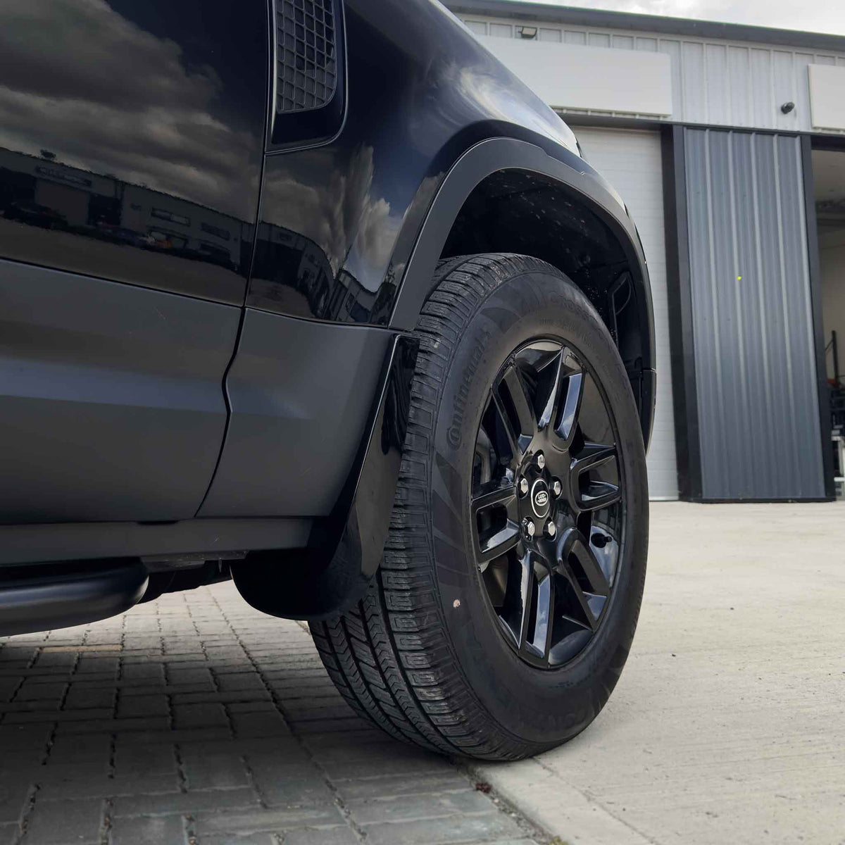 Gloss black mud flaps for Land Rover Defender L663 110 and 90 by CT Carbon, designed as durable vehicle accessories.