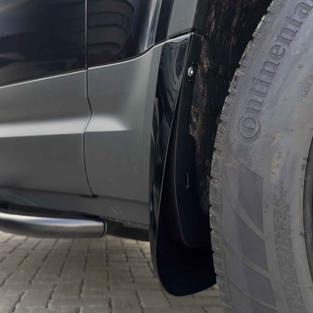 Gloss black mud flaps for Land Rover Defender L663 110 and 90, made by CT Carbon, designed to protect vehicle sides from mud and debris.