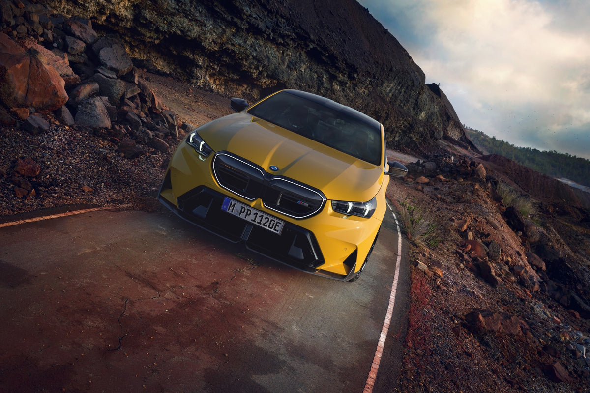 Genuine BMW G90 G99 M5 saloon front splitter in gloss carbon, enhancing aerodynamics and sporty appearance.