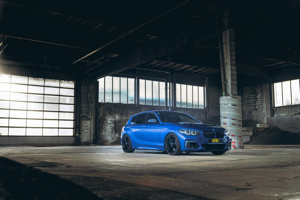ST Suspension coilovers for BMW F20/F21 M140i and F22/F23 M235i models, showing adjustable shock absorbers and mounting hardware.