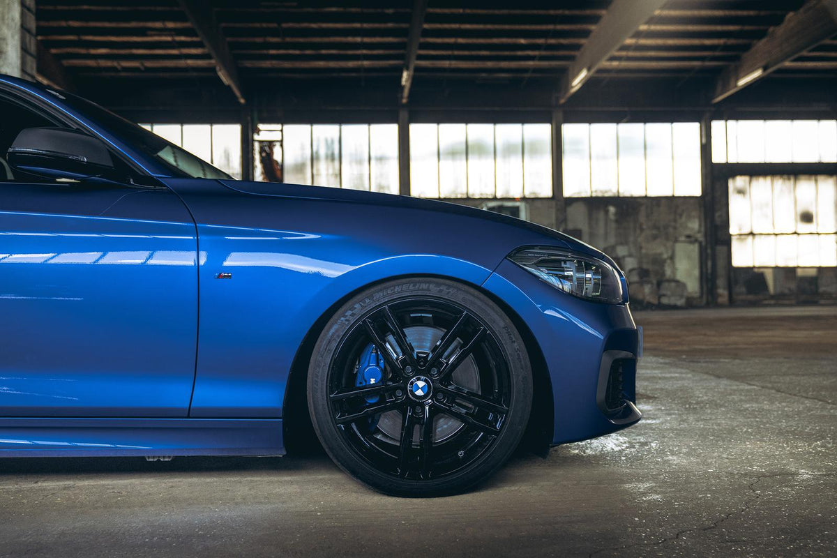 ST Suspension coilovers installed on BMW F20 M140i showing adjustable shock absorbers and lowered stance.