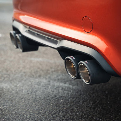 Pair of Cobra Sport 4-inch twin inward rolled carbon fiber exhaust tips for BMW M2 Competition, showcasing sleek, polished design.