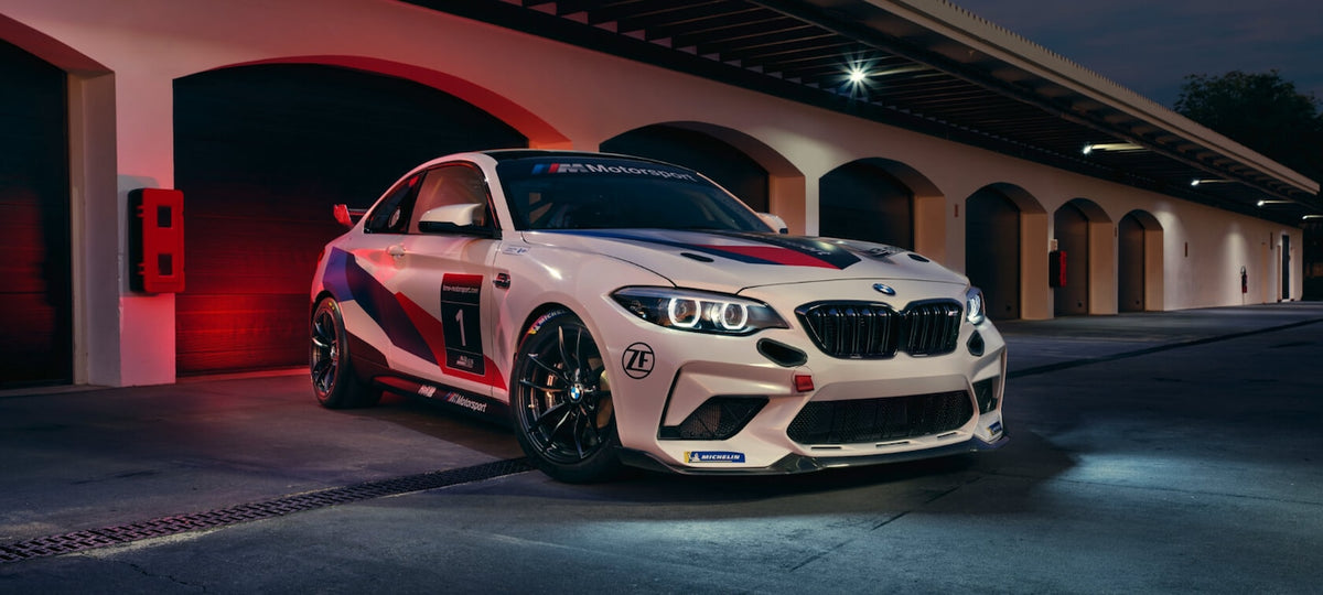 Genuine BMW Motorsport M2 CS racing tow strap attached to the front of a BMW M2 CS car for performance and safety.