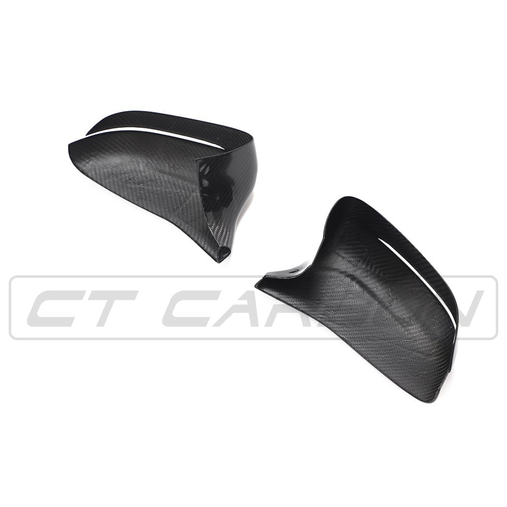 BMW F90 M5 M5C Competition carbon fiber mirror overlay by CT Carbon, RHD side, close-up of sleek black carbon fiber finish.
