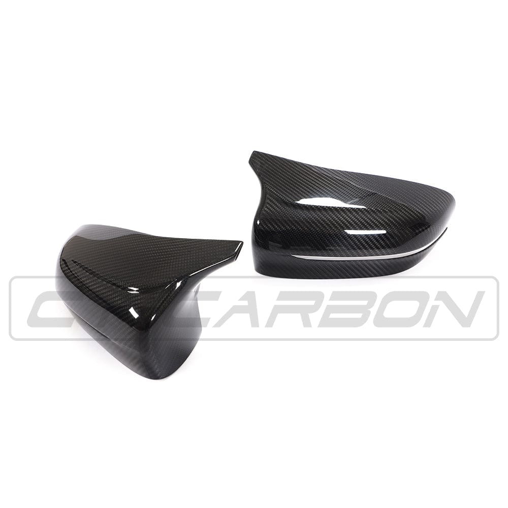BMW F90 M5 M5C Competition carbon fiber mirror overlay by CT Carbon, RHD side, close-up view of sleek, textured carbon fiber exterior.