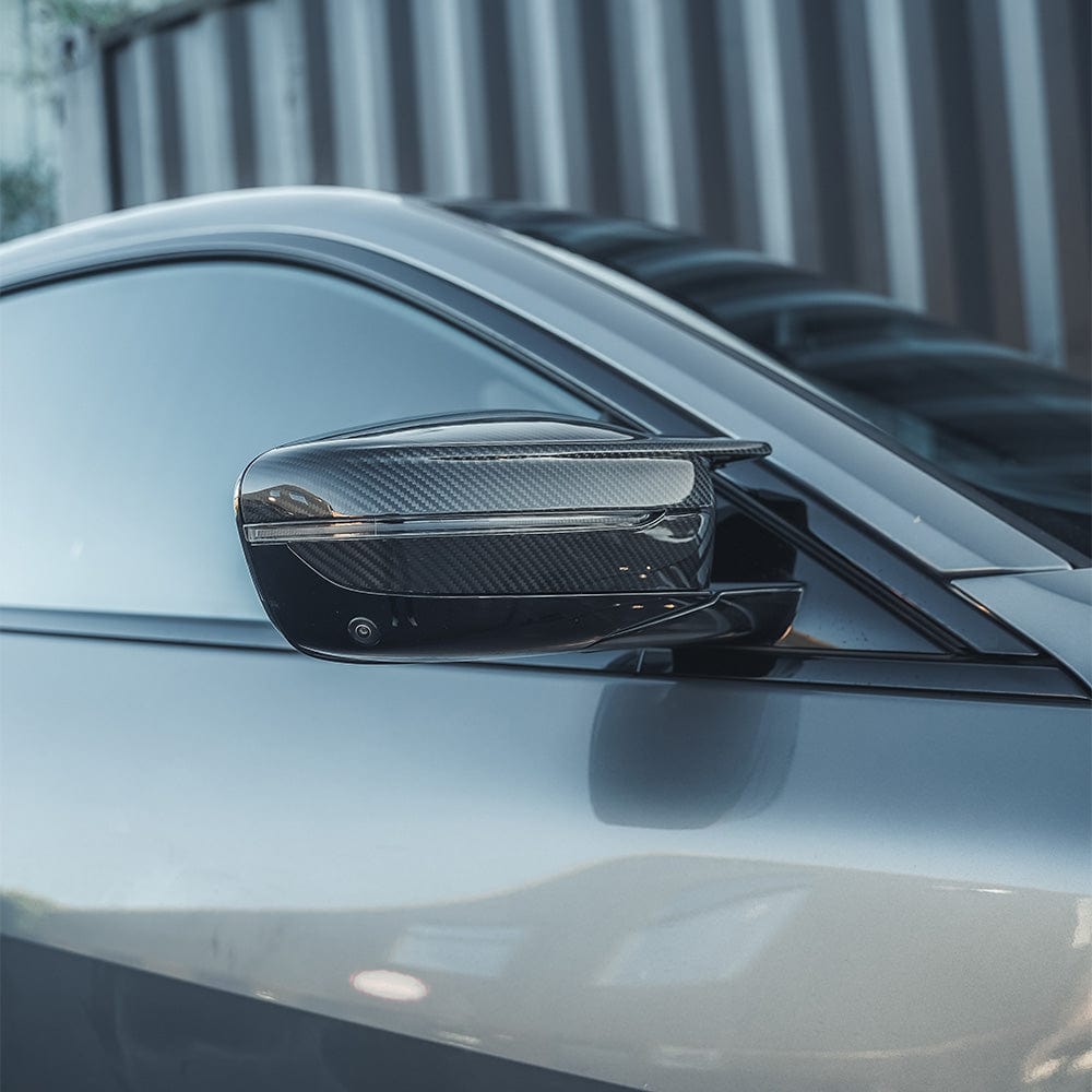 BMW M3 M4 G80 G82 G83 G87 carbon fiber replacement mirrors by CT Carbon, RHD, sleek aerodynamic design for enhanced style.