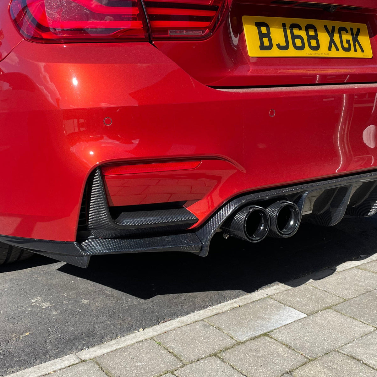 BMW M3 M4 F80 F82 F83 rear carbon fiber bumper canards by CT Carbon, showing aerodynamic car accessory with sleek finish