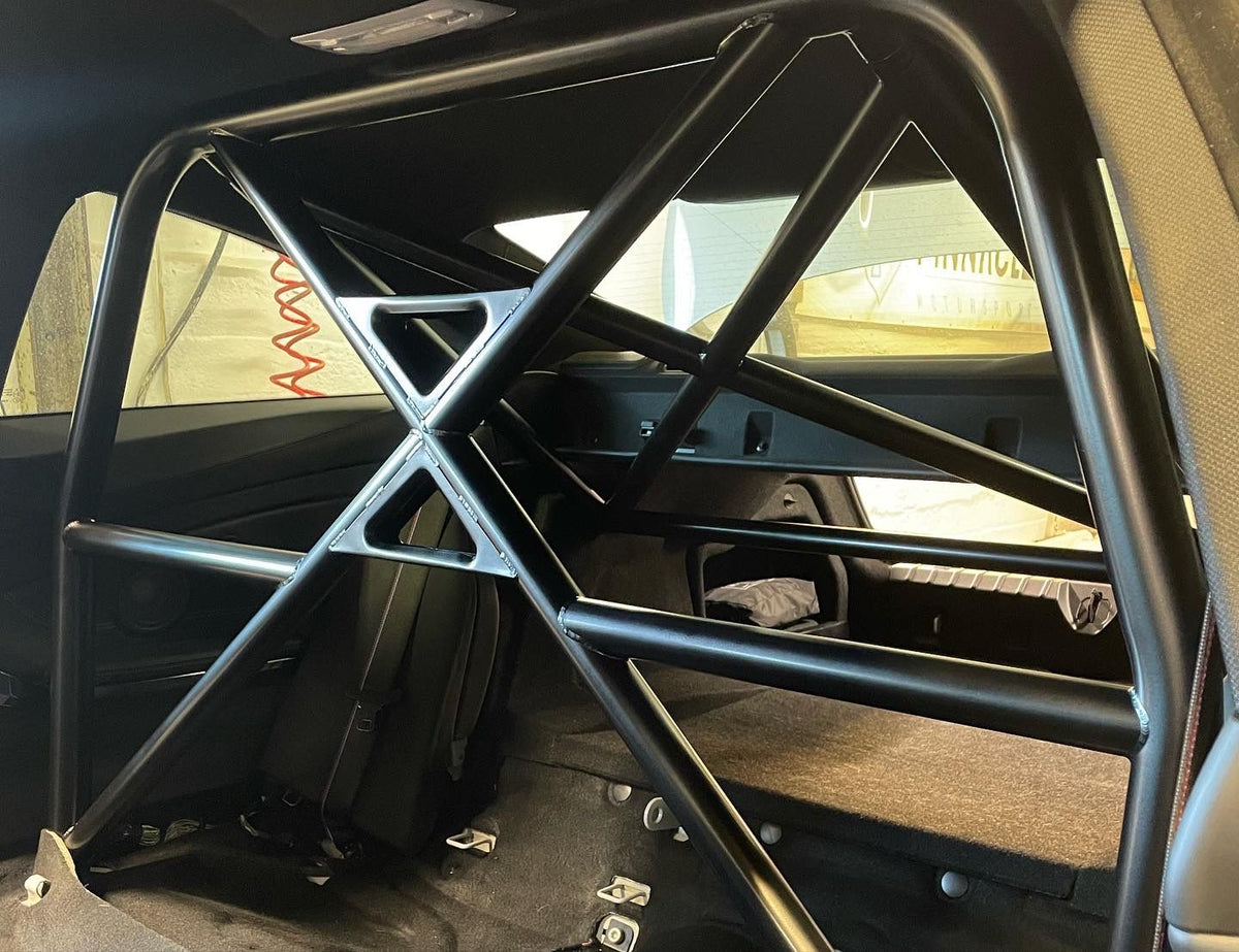 PINNACLE M4 GTS style T45 half cage roll cage installed in a car interior for enhanced safety and structural support.