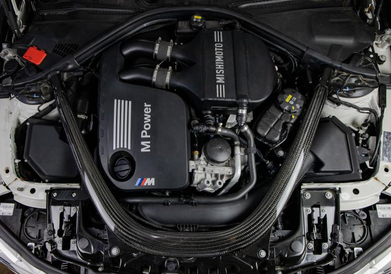 MISHIMOTO performance air-to-water intercooler for BMW F8X M3 M4 2015-2020 engine, shown installed in the engine bay.
