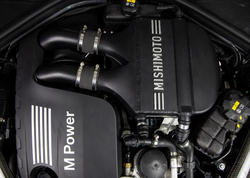 MISHIMOTO performance air-to-water intercooler for BMW F8X M3 M4, engine cooling upgrade, shown installed in engine bay.