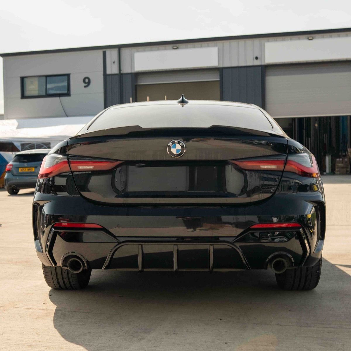 BMW G22 G23 4 Series 2020-2024 CT Carbon gloss black round tip diffuser installed on the rear of the vehicle.
