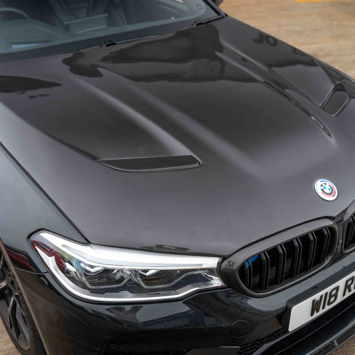 BMW F90 M5 and G30 5 Series carbon fiber bonnet by CT Carbon, showing the sleek, lightweight design with textured carbon fiber surface.