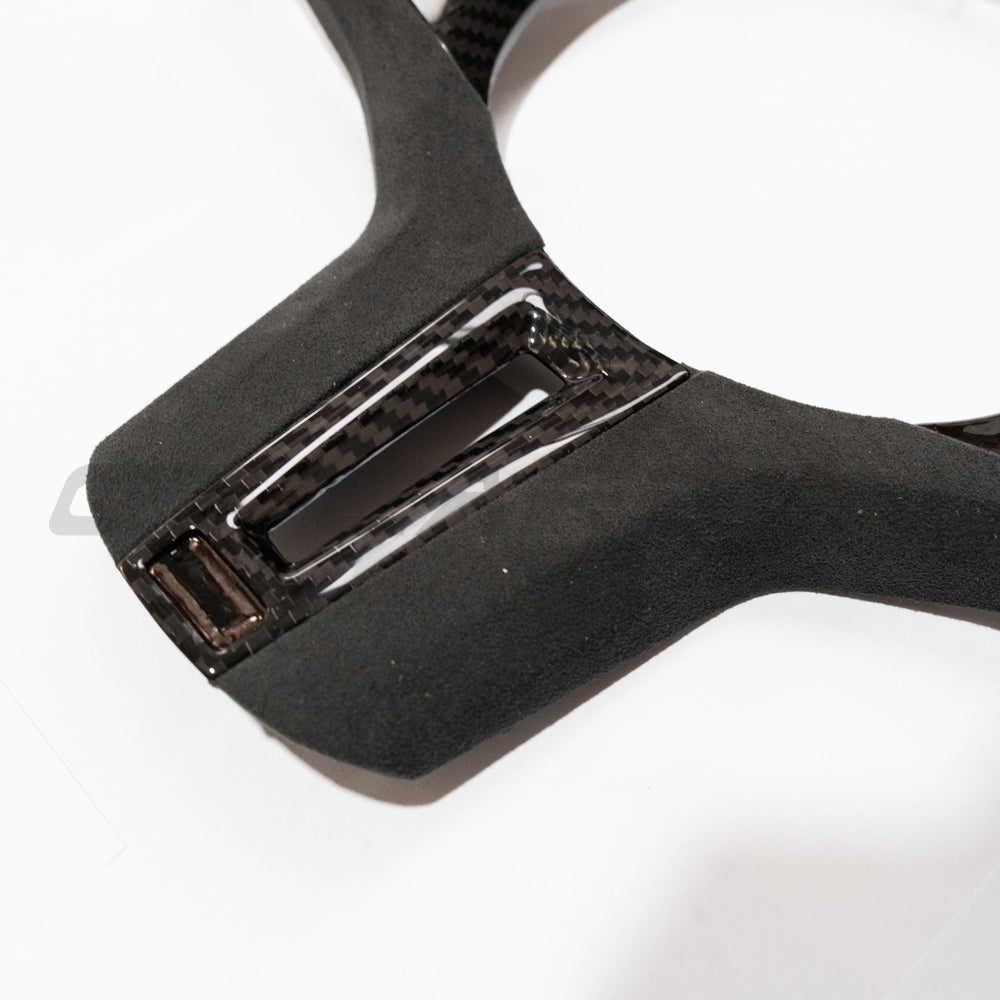 BMW Gxx M/M-SPORT carbon fiber steering wheel trim accessory by CT Carbon, showing close-up of sleek, textured carbon fiber finish.