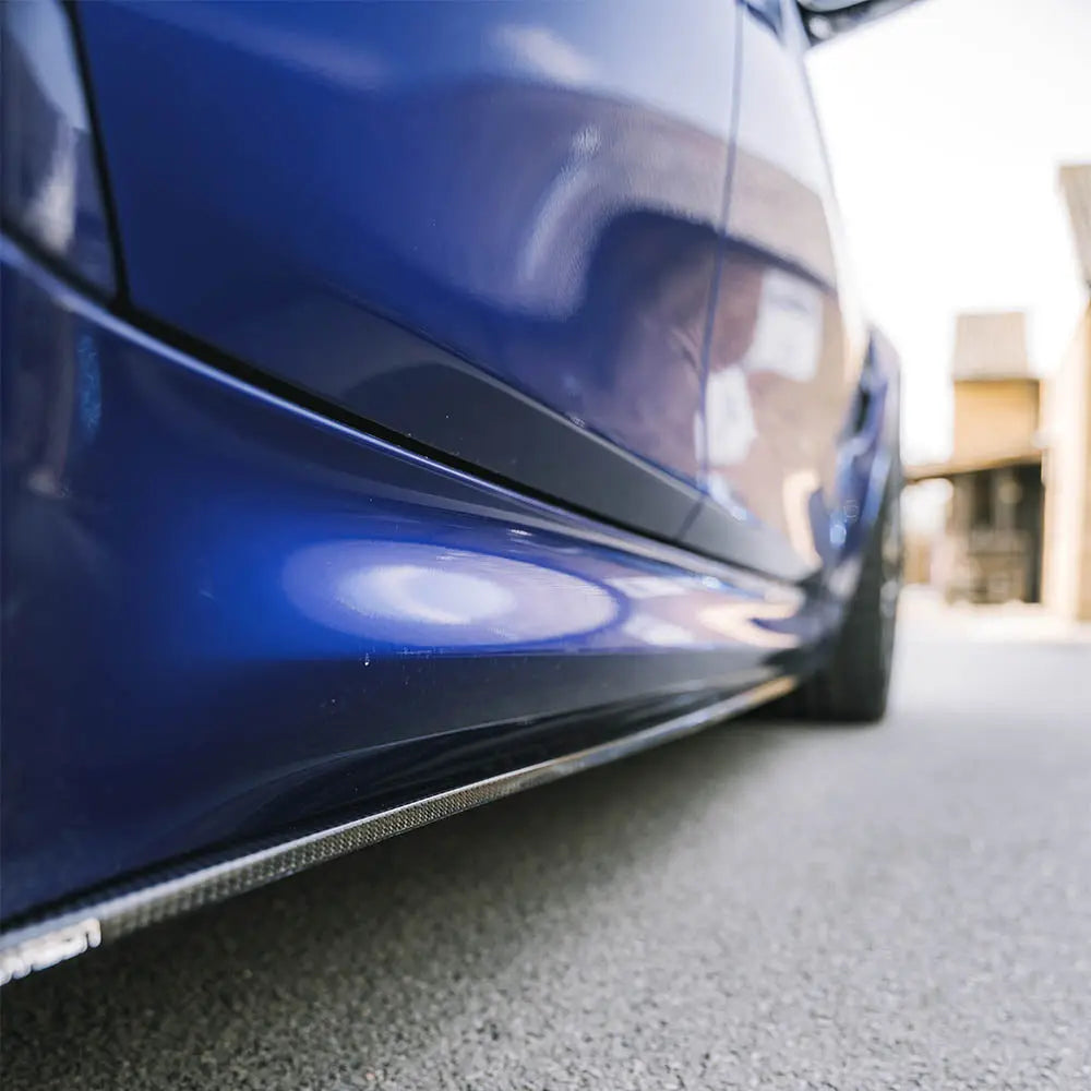 BMW M3 M4 F80 F82 F83 carbon fiber side skirts by CT Carbon, showcasing sleek V1 style on a sporty vehicle.