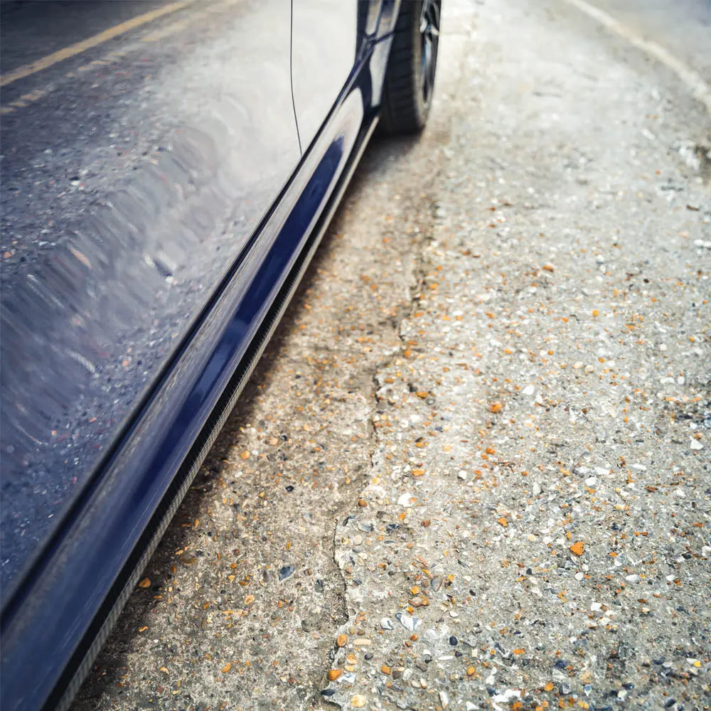 BMW M3/M4 F80/F82/F83 carbon fiber side skirts by CT Carbon, showing sleek V1 design and textured finish on the vehicle.