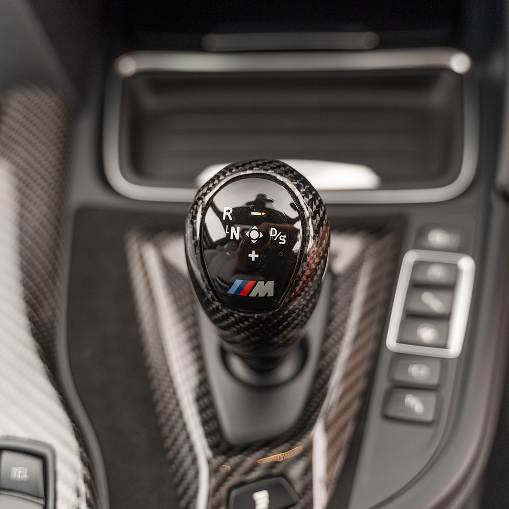 BMW M3 M4 F80 F82 F83 F87 ALCANTARA and carbon shifter surround accessory by CT Carbon, LHD model with sleek black finish.