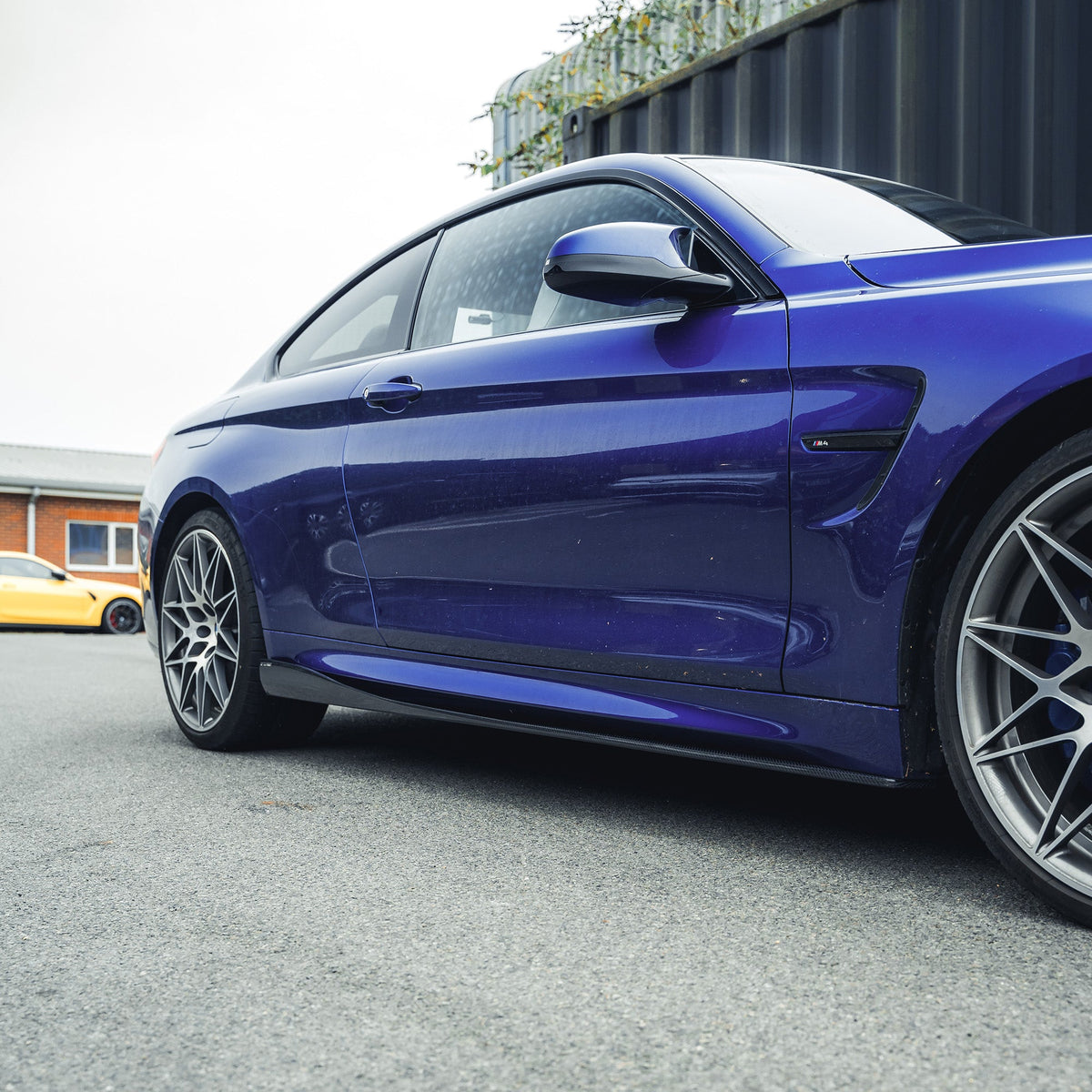 BMW M3 M4 F80 F82 carbon fibre side skirts by CT Carbon, showing sleek, aerodynamic design on the car's side profile.