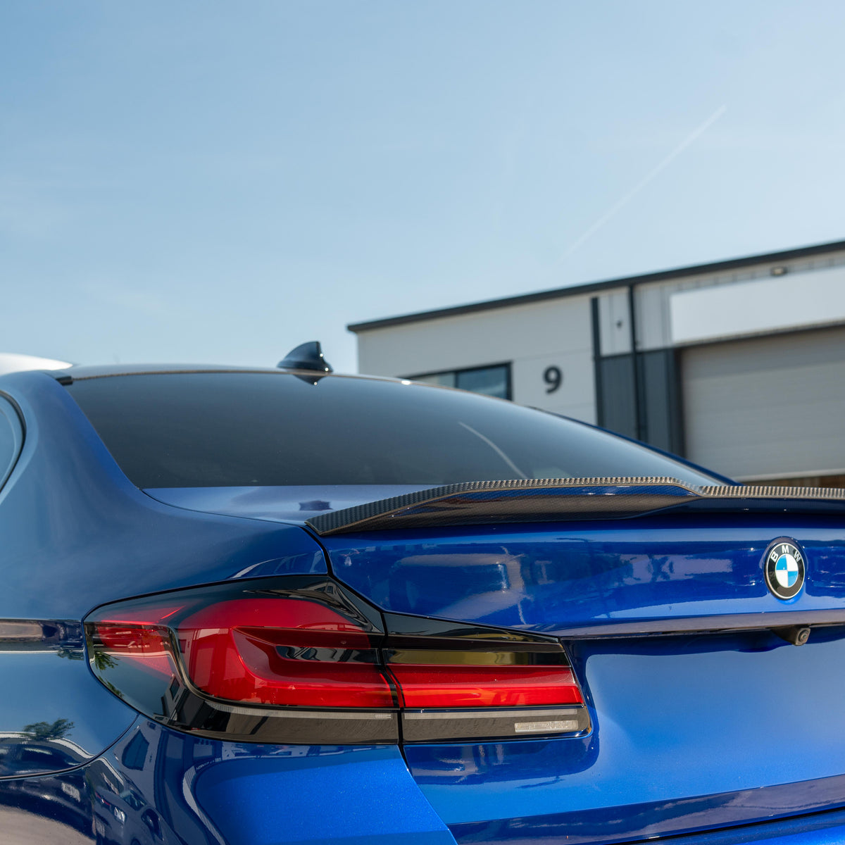 BMW M5 F90 and G30 5 Series carbon fiber spoiler by CT Carbon, showing sleek aerodynamic design on a dark sports car.