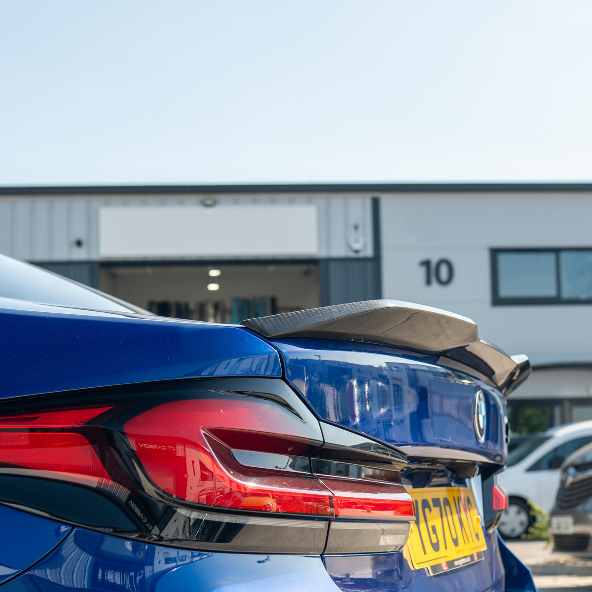 BMW M5 F90 and G30 5 Series carbon fibre spoiler by CT Carbon, shown on a sleek black car with close-up angle.