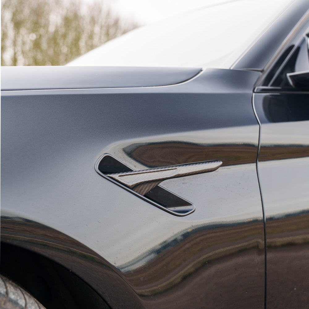BMW F90 M5 carbon fiber fender trim accessory by CT Carbon, showcasing sleek, textured carbon fiber details on the car's fenders.