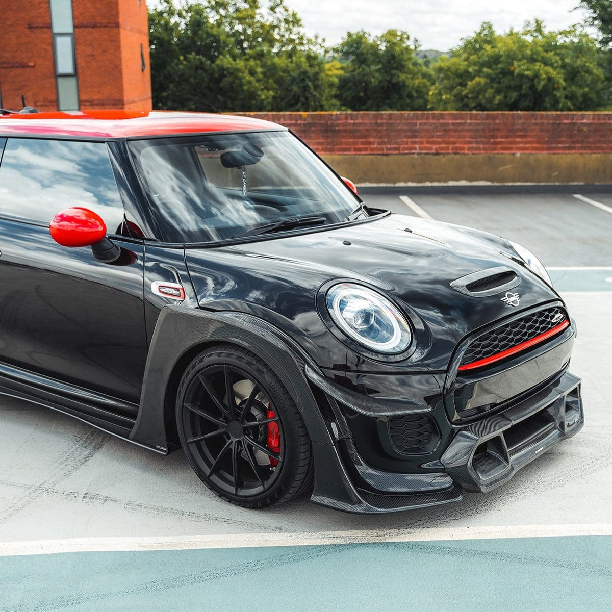 Mini Cooper S F56 JCW Sport Pack carbon fiber wide arch kit installed, showcasing aggressive wide fender extensions and sporty design.