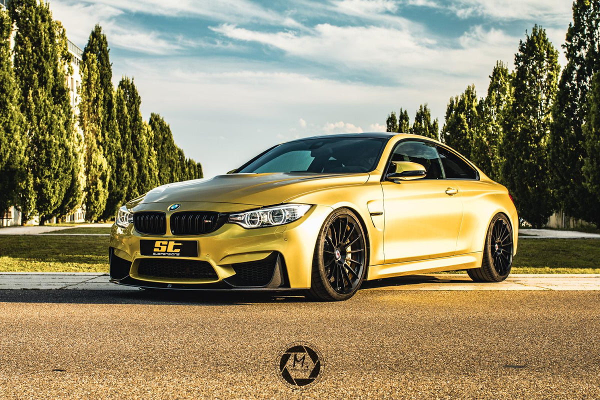 Gold ST Suspension coilovers installed on BMW F82 M4 Coupe, featuring adjustable damping and top mounts for enhanced performance.