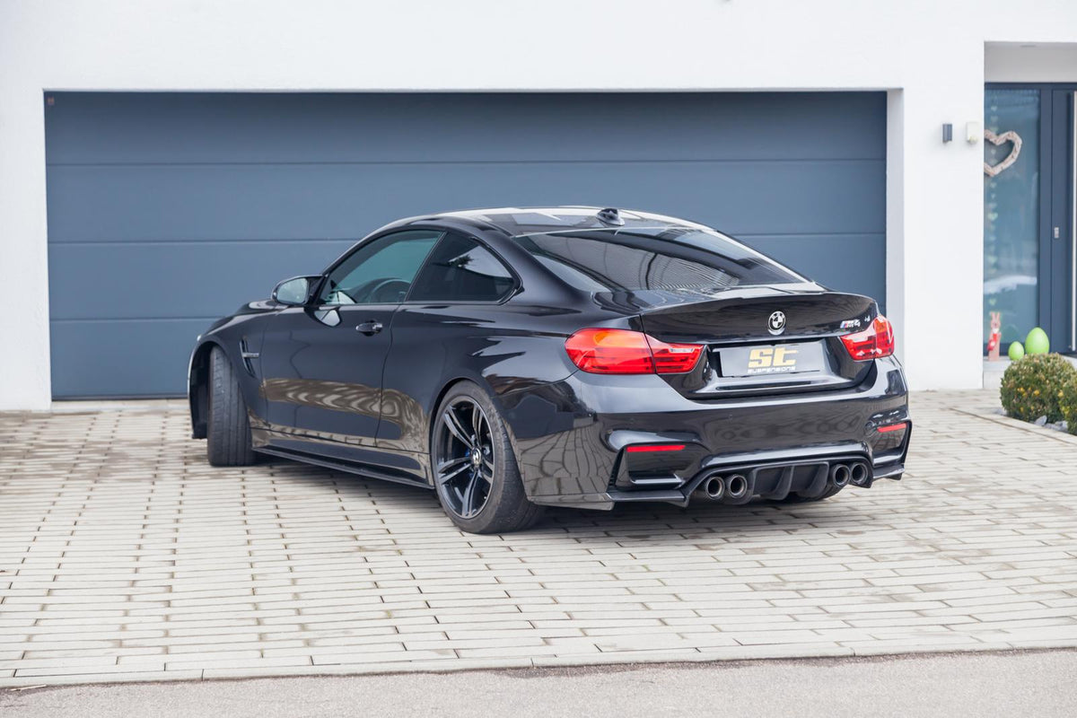 ST Suspension coilovers for BMW F80 M3, F82 M4, and F83 M4 with adjustable damping and top mounts, shown on a coupe.