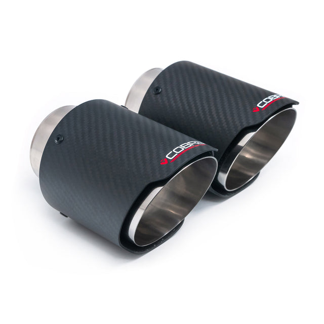 Pair of Cobra Sport 4-inch carbon fiber slash cut exhaust tips with polished finish on a vehicle tailpipe