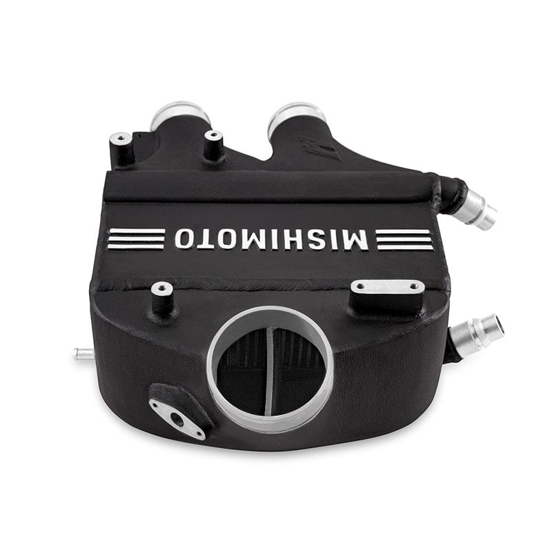 MISHIMOTO performance air-to-water intercooler installed in a BMW F80 M3 or M4 engine, showing the sleek metal core and fittings.
