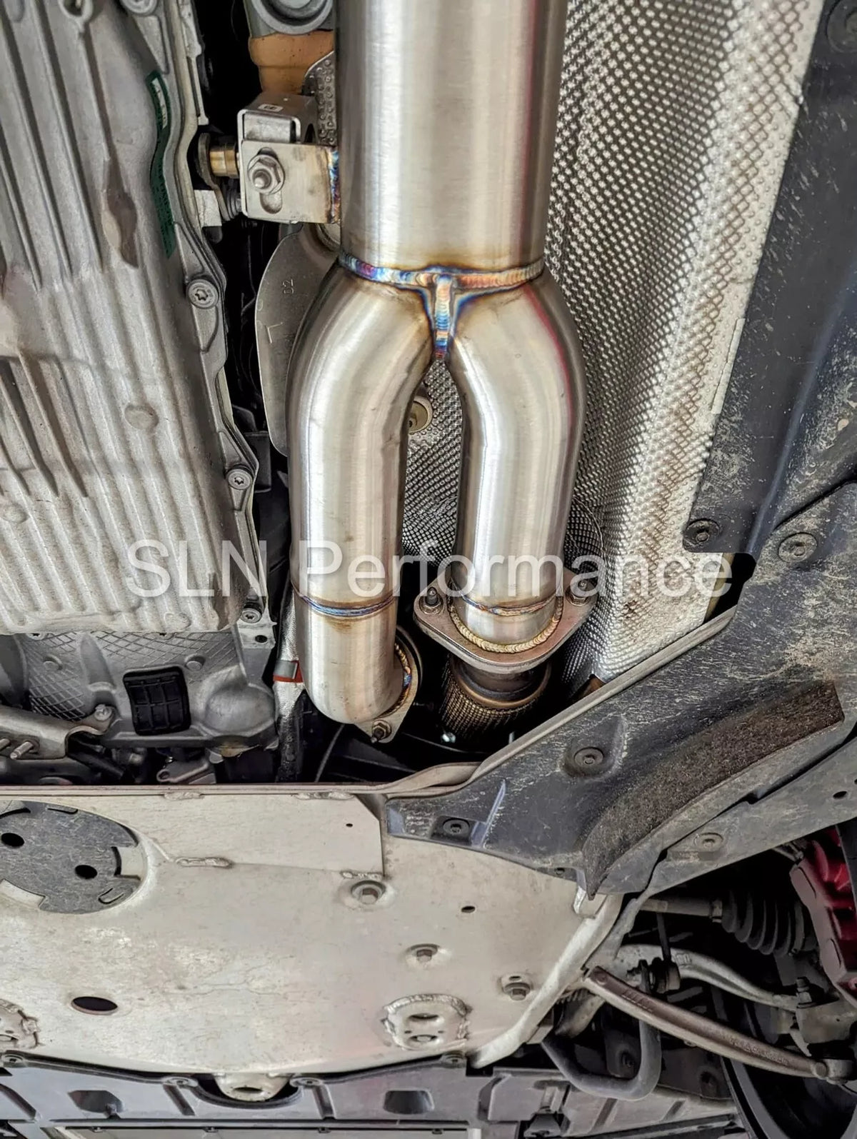 SLN Performance BMW S58 M3 G80 M4 G82 X3M X4M LCI single mid pipe center section with under-brace, showcasing polished metal and mounting points.